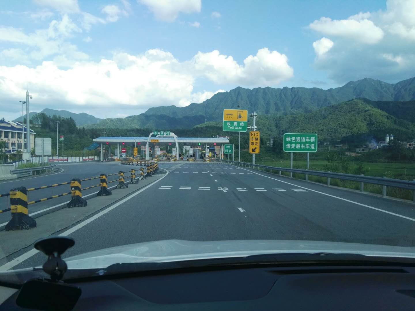 蓝天白云下的大山与反光漆路牌点缀成画